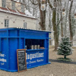 ein Glühnweinstand in der Form eines überdimensionalen blauen Augustiner - Bierkastens