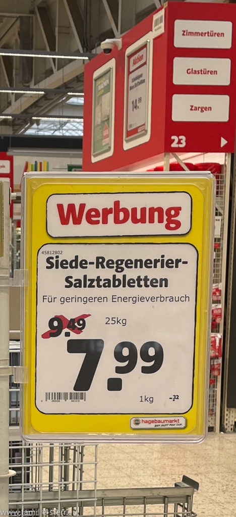 Schild mit einem besonderen Preisangebot für Regeneriersalz im Baumarkt