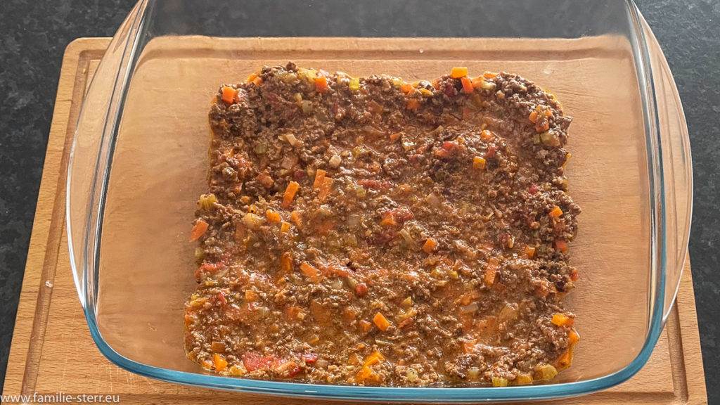 eine erste Schicht Bolognese - Soße als Grundlage für die hausgemachte Lasagne