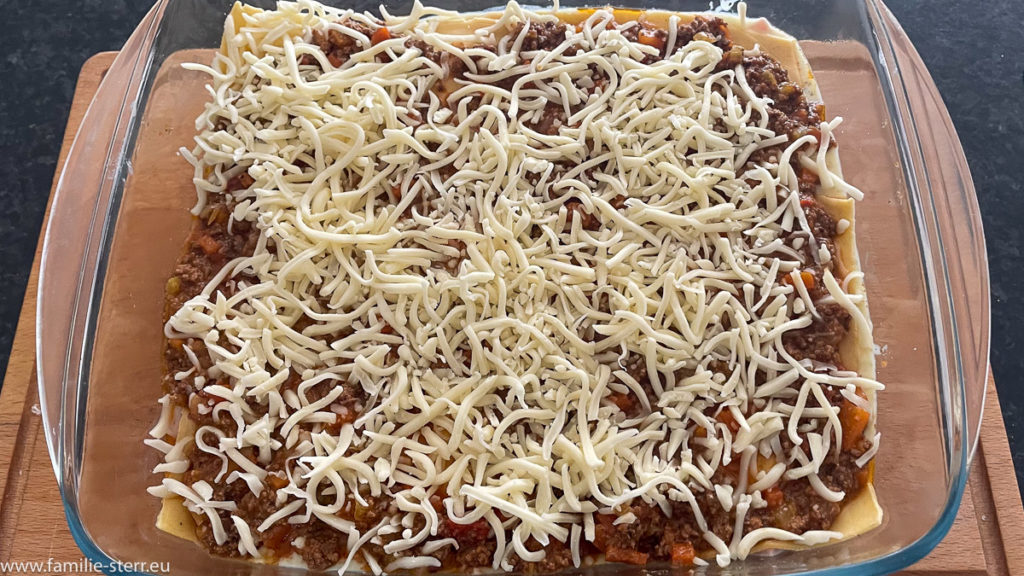 etwas geriebener Käse als Zwischenschicht für die hausgemachte Lasagne