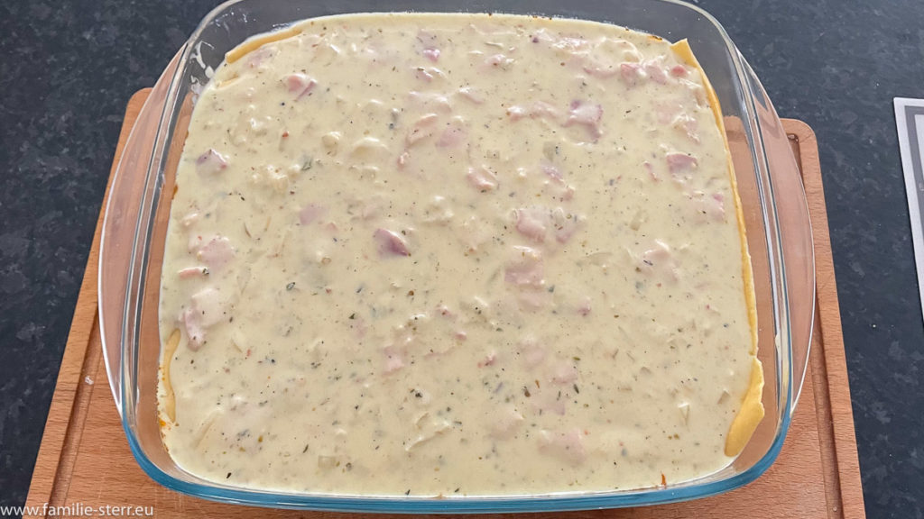 Bechamelsauce mit Schinken und Zwiebeln als Schicht in der Lasagne