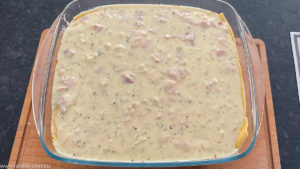 Bechamelsauce mit Schinken und Zwiebeln als Schicht in der Lasagne