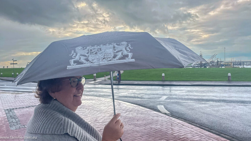 Astrid mit einem Regenschirm mit Bayernwappen in Norddeich an der Nordsee