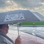 Astrid mit einem Regenschirm mit Bayernwappen in Norddeich an der Nordsee