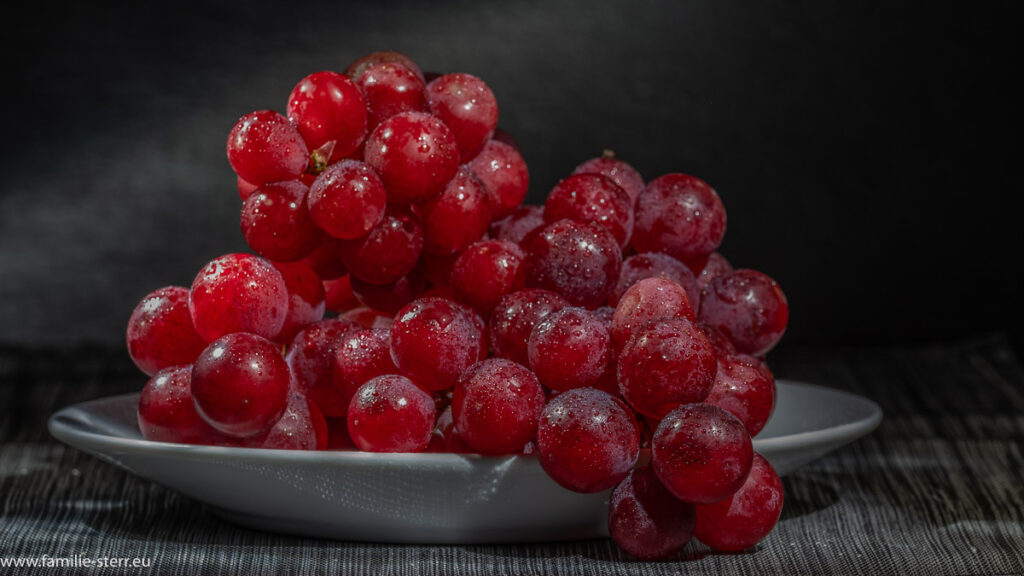 rote Weintrauben auf einem weißen Teller