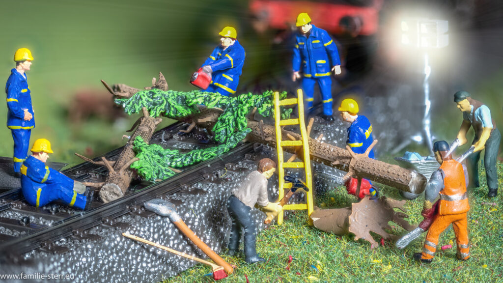 ein Trupp Helfer versucht, einen umgestürzten Baum vom Gleis zu bekommen - H0-Modellbahn-Szene