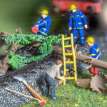 ein Trupp Helfer versucht, einen umgestürzten Baum vom Gleis zu bekommen - H0-Modellbahn-Szene