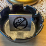 ein "nicht-rauchen"- Schild in einem Aschenbecher