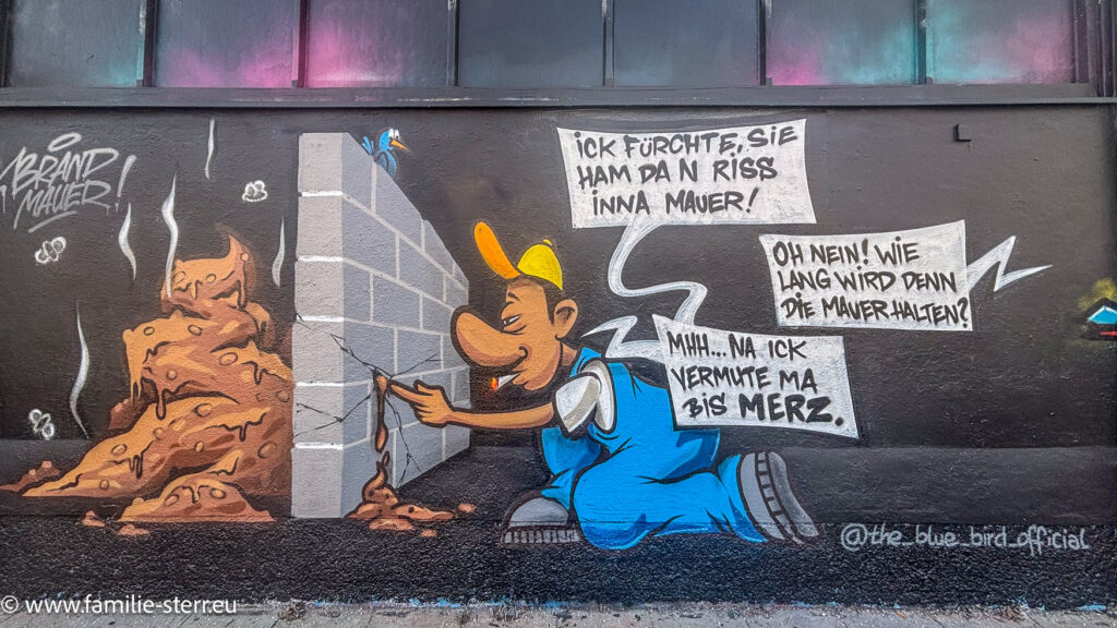 ein Cartoon - Graffiti zur Brandmauer der CDU und Friedrich Merz an der Mauer der Großmarkthalle München