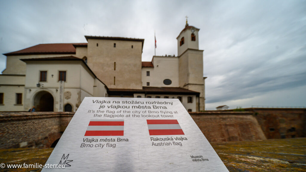 Schild mit einer Erklärung, dass die Fahne auf dem Mast an der Festung Spielberk nicht die österreichische Flagge ist