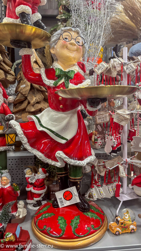 Figur einer fröhlichen Oma im Weihnachtsmannkostüm mit einem Serviertablett beim Schirsch