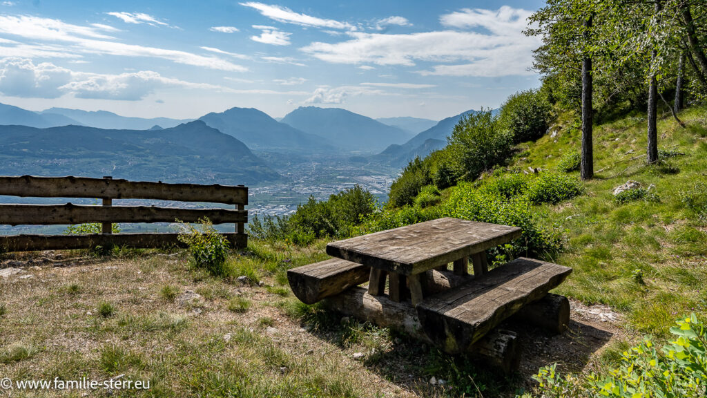 ein Picknicktisch an einem Wanderweg mit Blick über das Etschtal bei Trient