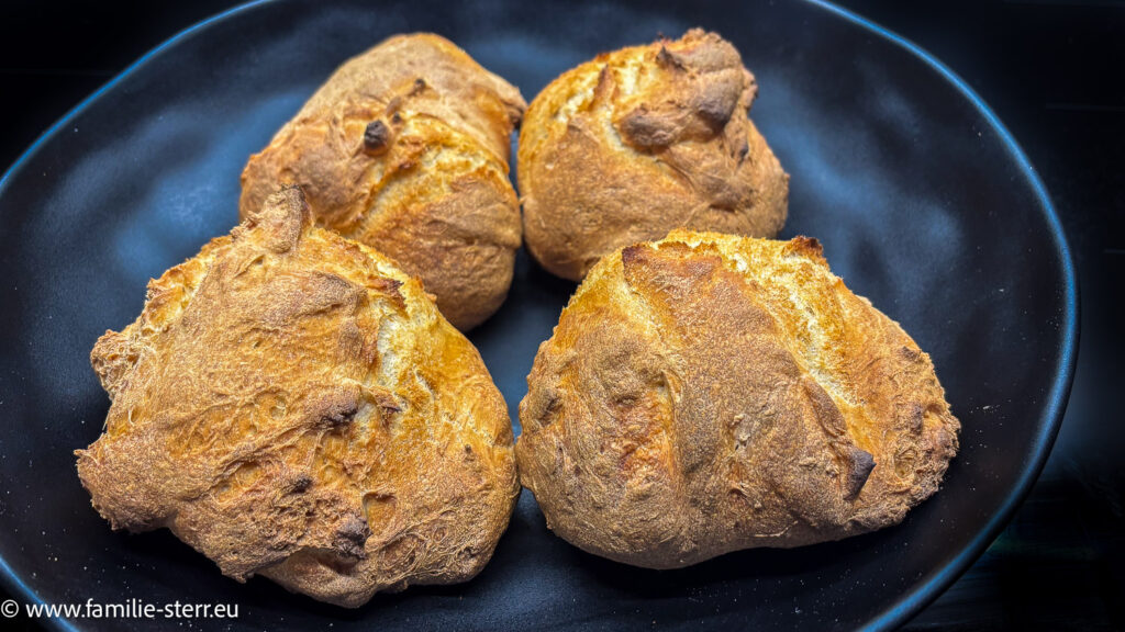 Ein paar frisch gebackene Bürli in einer schwarzen Schale für das Frühstück an Weihnachten
