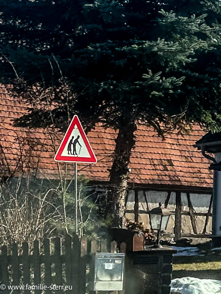 Eine Warnschild, das Autofahrer auf langsame Senioren in freier Wildbahn (auf der Straße) warnt