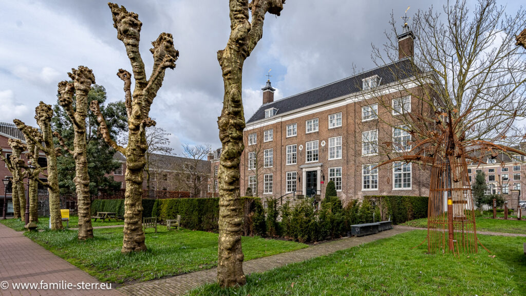 Gebäude der Diakonie in Amsterdam im Park hinter einer Reihe von Bäumen